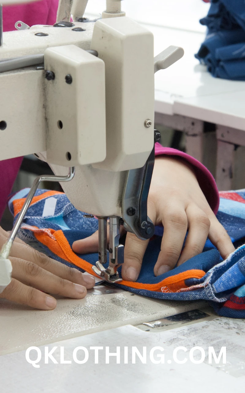 A modern garment factory floor with a line of skilled workers operating industrial sewing machines for cut and sew production.
