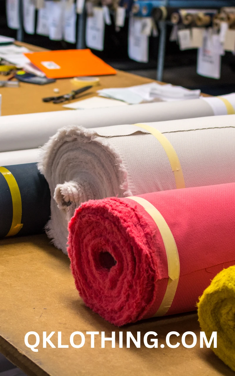 Fashion designer in a bright studio selecting from a vibrant collection of sustainable fabric rolls for custom apparel.